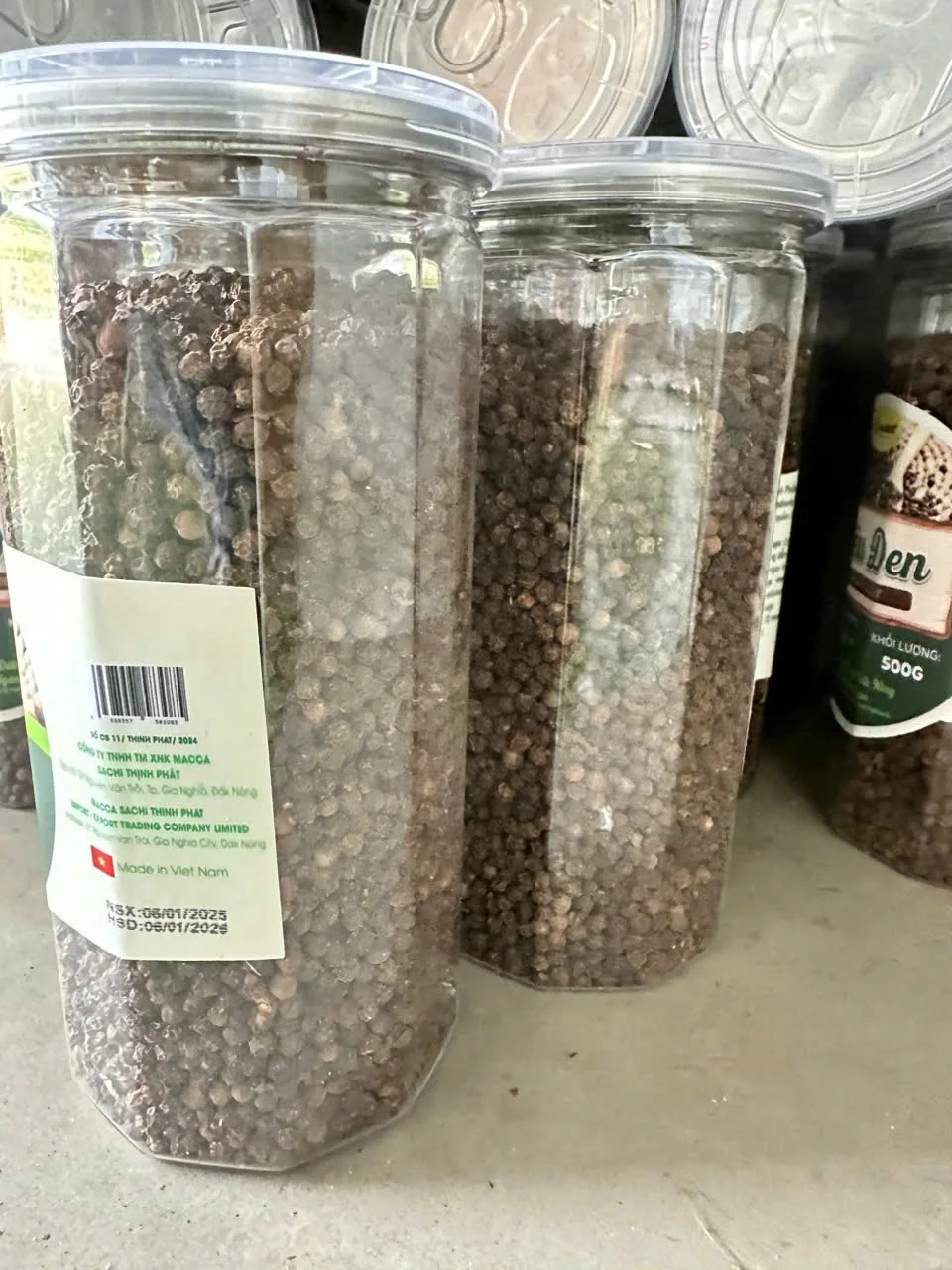 Ganze vietnamesische schwarze Pfefferkörner in transparenten Behältern